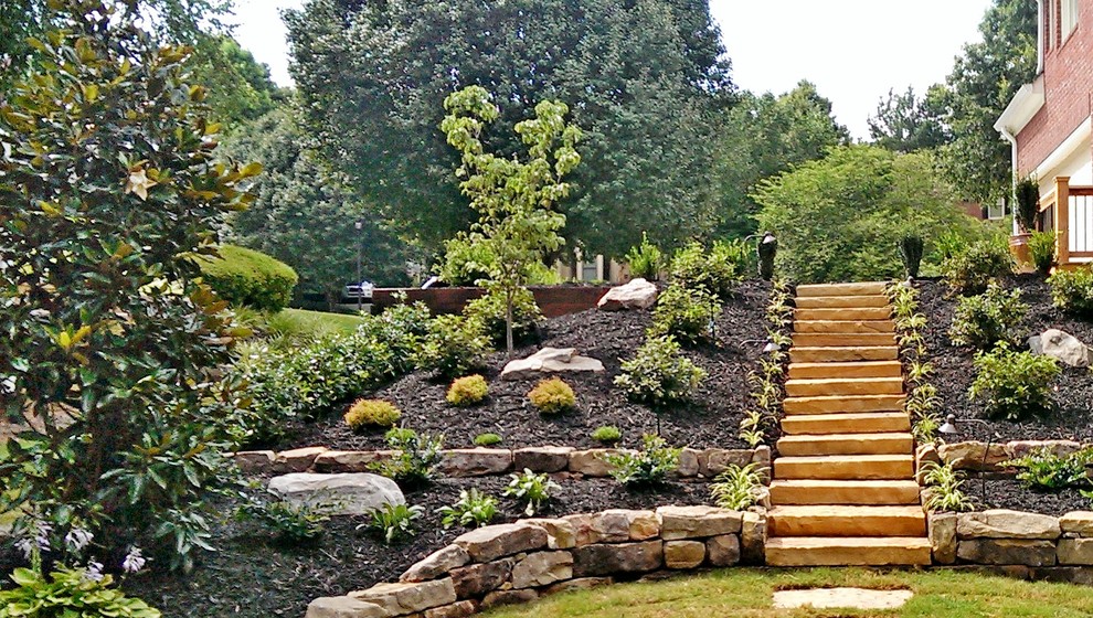 Idee per un grande giardino formale chic nel cortile laterale con un muro di contenimento e pavimentazioni in pietra naturale