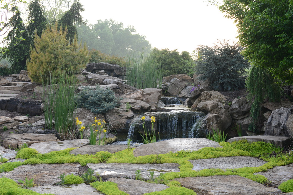 Design ideas for a large traditional partial sun backyard stone landscaping in St Louis for summer.