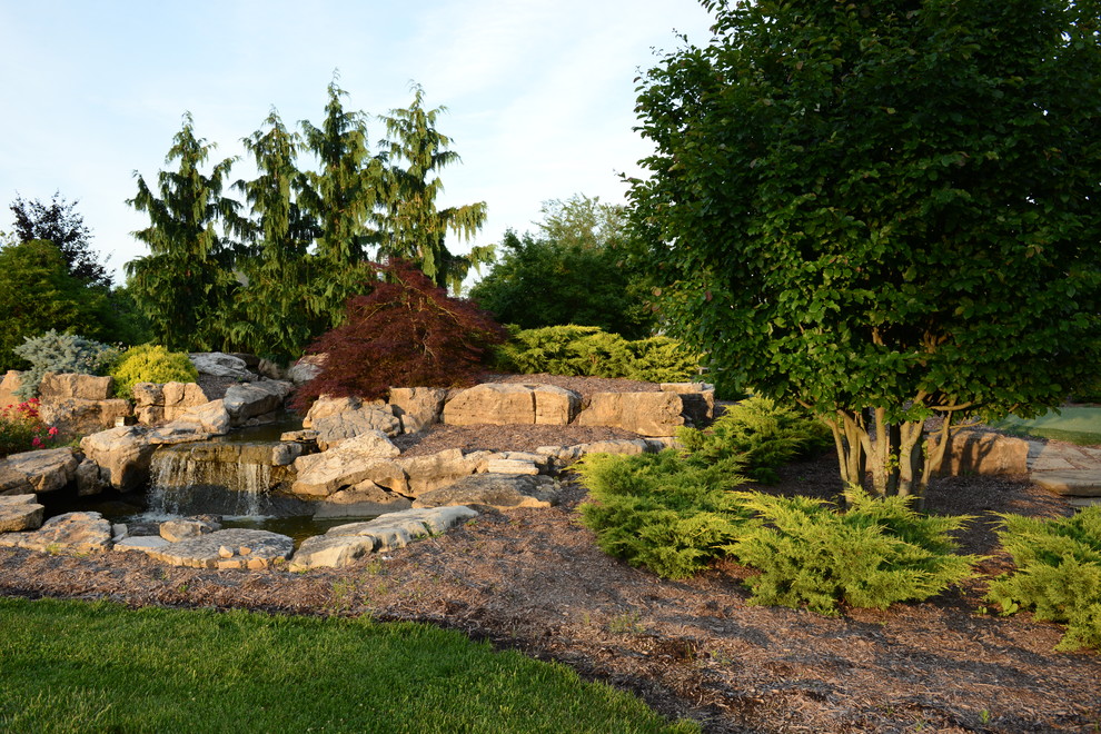 Immagine di un grande giardino tradizionale esposto a mezz'ombra dietro casa in estate con pavimentazioni in pietra naturale