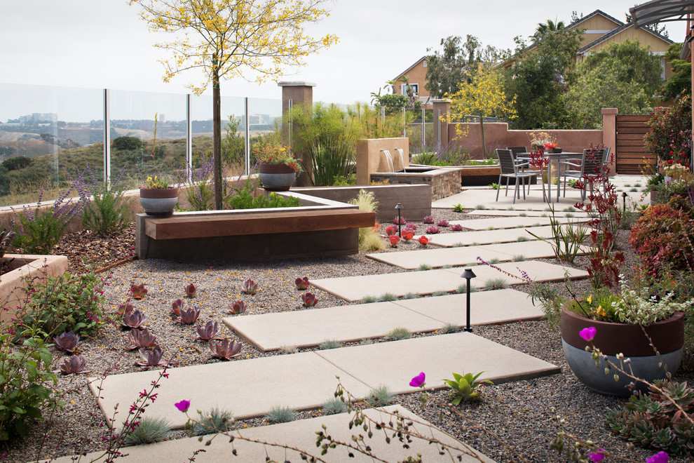 Ispirazione per un giardino xeriscape minimal esposto in pieno sole di medie dimensioni e in cortile in primavera con un muro di contenimento e pavimentazioni in cemento