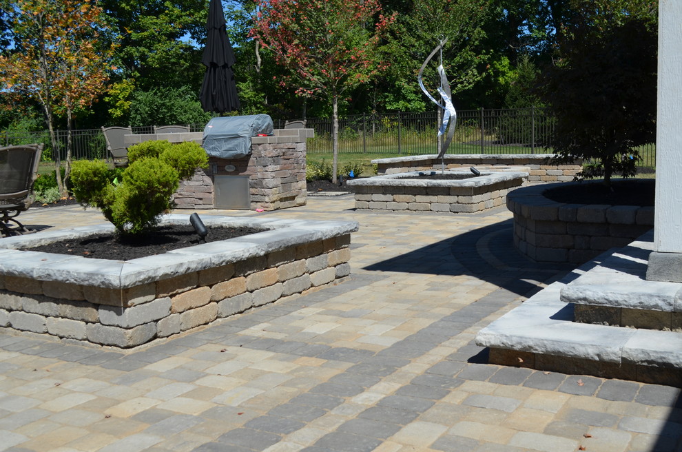 Inspiration for a large eclectic partial sun backyard stone landscaping in Columbus with a fire pit.