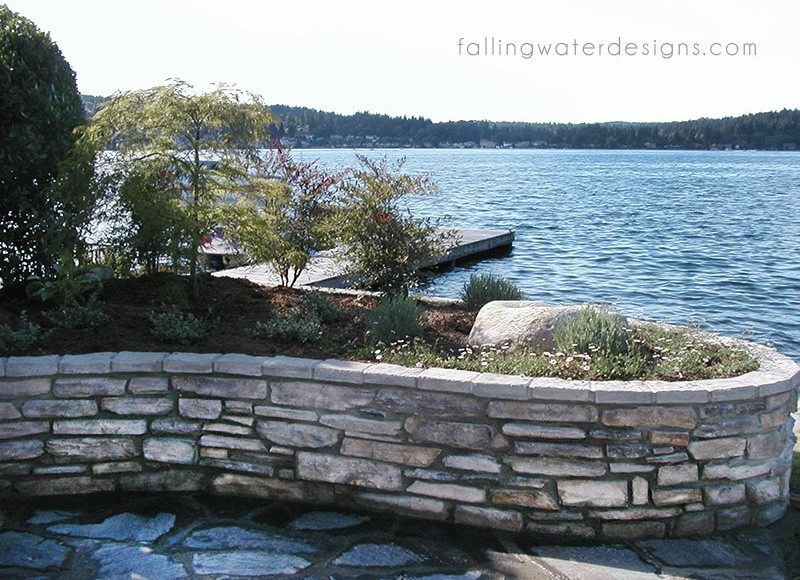 Design ideas for a huge contemporary partial sun backyard stone retaining wall landscape in Seattle for summer.