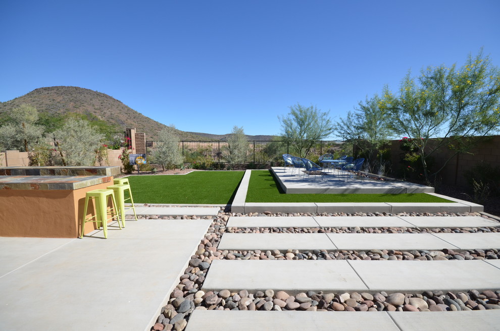 Inspiration for a mid-sized modern full sun backyard concrete paver landscaping in Phoenix for summer.