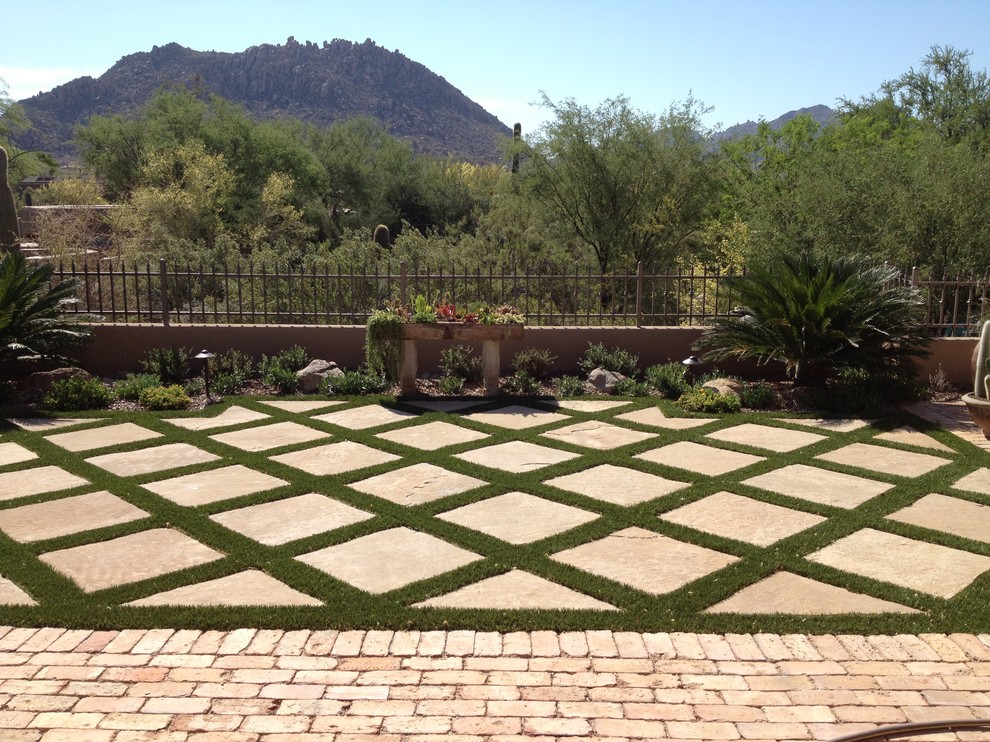 This is an example of a medium sized mediterranean back formal garden in Phoenix with brick paving.