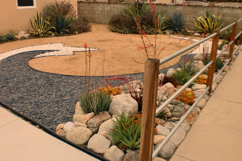 Cette image montre un jardin avant sud-ouest américain de taille moyenne avec une exposition ensoleillée et du gravier.