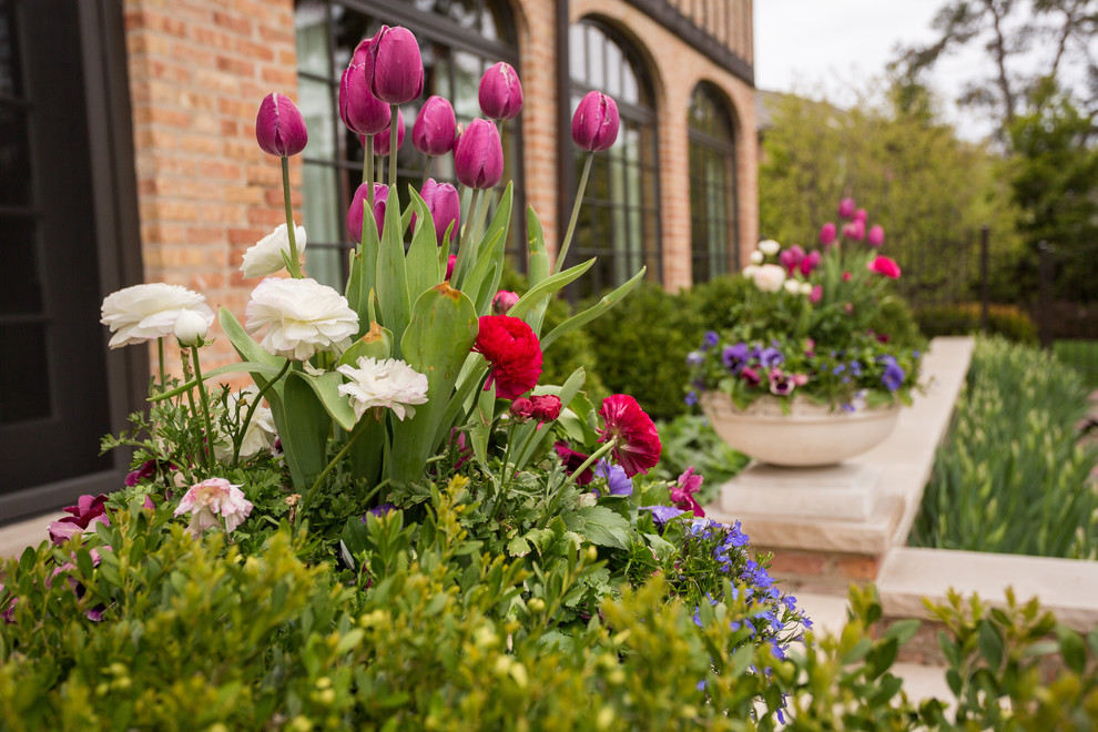 Diseño de jardín clásico grande en primavera en patio trasero con jardín de macetas, exposición total al sol y adoquines de piedra natural