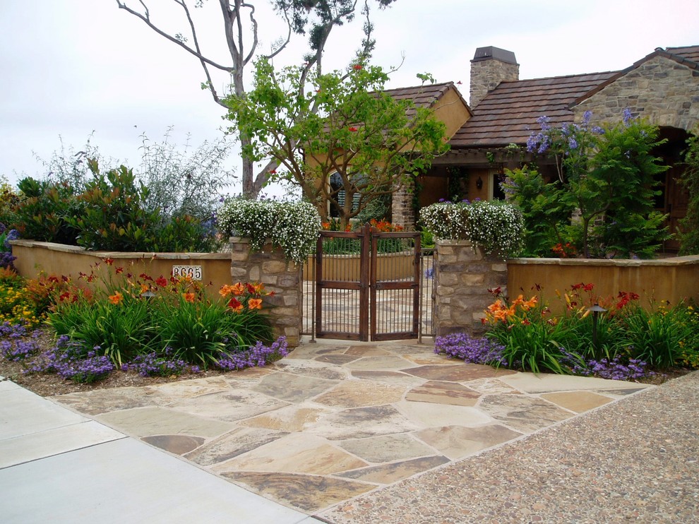 Photo of a mediterranean full sun front yard stone landscaping in San Diego.