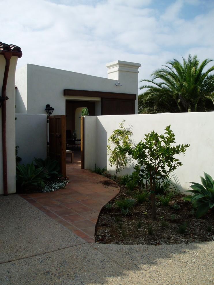 Ejemplo de jardín mediterráneo de tamaño medio en patio trasero con brasero, exposición parcial al sol y adoquines de piedra natural