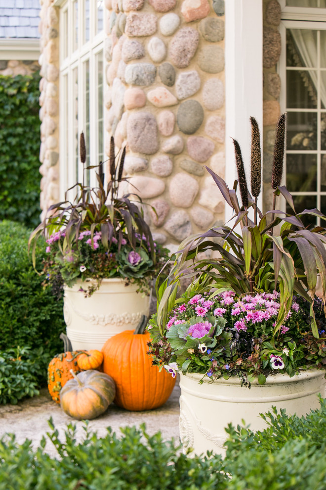 Foto de jardín clásico renovado de tamaño medio en otoño en patio delantero con jardín de macetas, exposición parcial al sol y adoquines de piedra natural