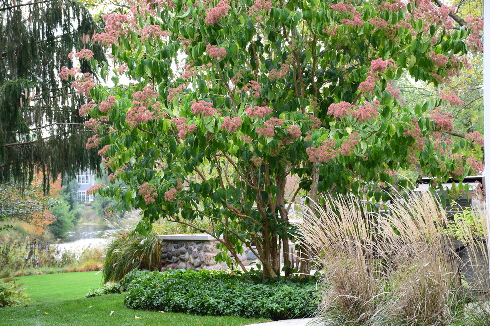 Exemple d'un jardin arrière chic l'automne avec une exposition ensoleillée et des pavés en pierre naturelle.