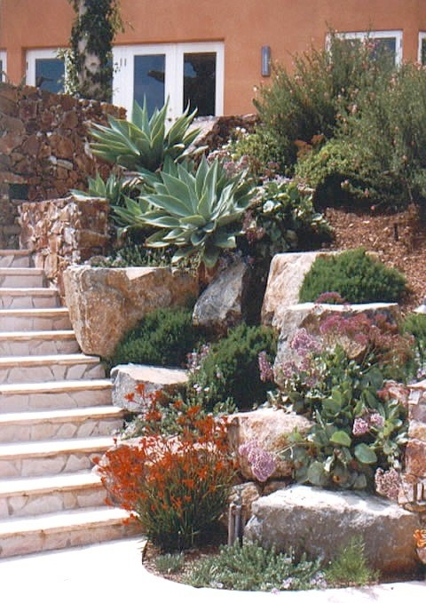 Стильный дизайн: большой солнечный участок и сад на переднем дворе в средиземноморском стиле с хорошей освещенностью и покрытием из каменной брусчатки - последний тренд