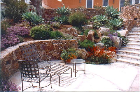 Пример оригинального дизайна: большой солнечный участок и сад на внутреннем дворе в средиземноморском стиле с садовой дорожкой или калиткой, хорошей освещенностью и покрытием из каменной брусчатки