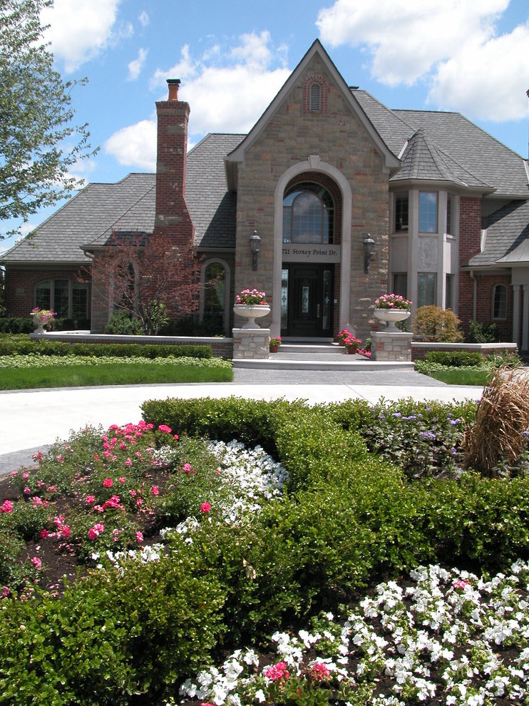 Inspiration for a traditional front formal full sun garden in Detroit with natural stone paving.