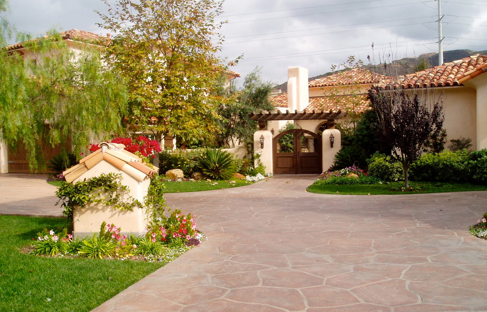 Mediterraner Vorgarten mit Auffahrt, direkter Sonneneinstrahlung und Natursteinplatten in San Diego