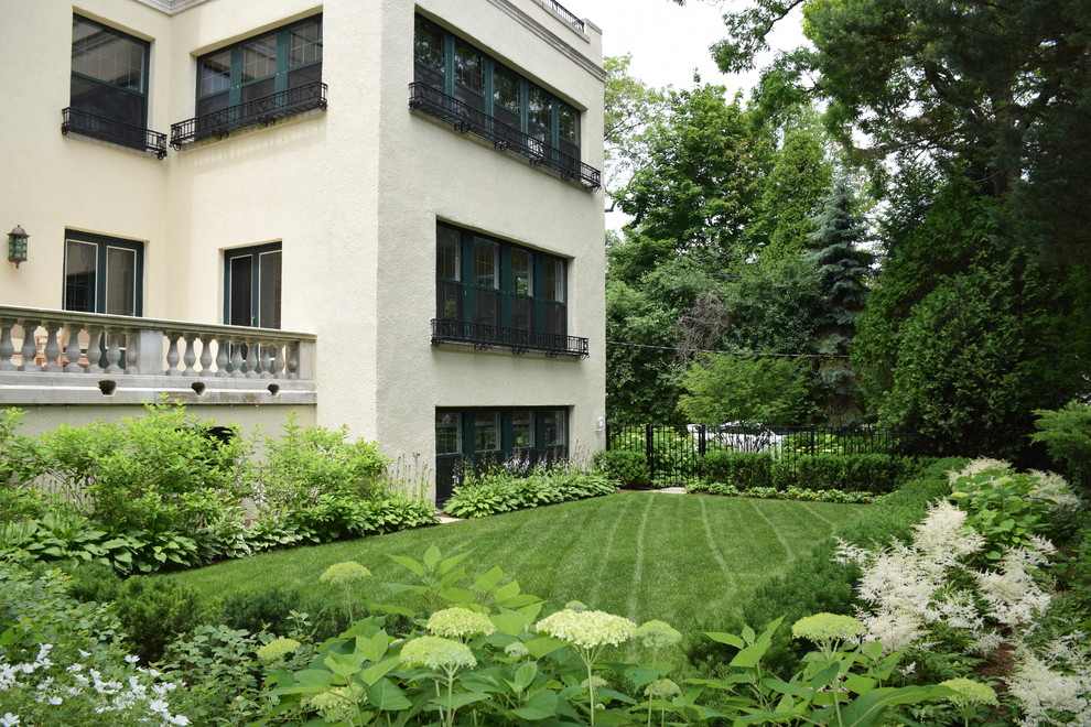Cette image montre un jardin à la française arrière traditionnel de taille moyenne et l'été avec une exposition partiellement ombragée.