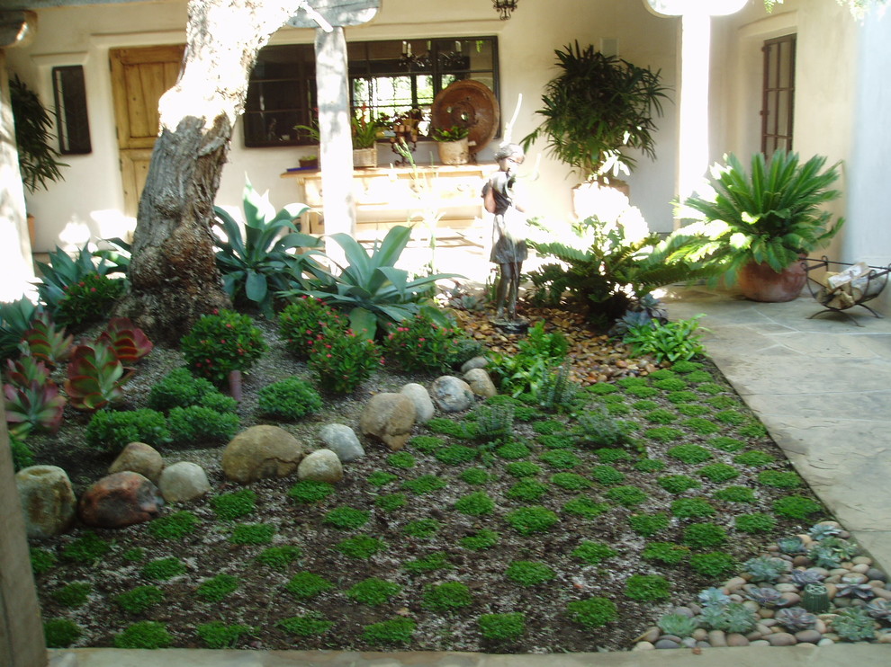 Свежая идея для дизайна: участок и сад на переднем дворе в средиземноморском стиле с растениями в контейнерах, полуденной тенью и покрытием из каменной брусчатки - отличное фото интерьера