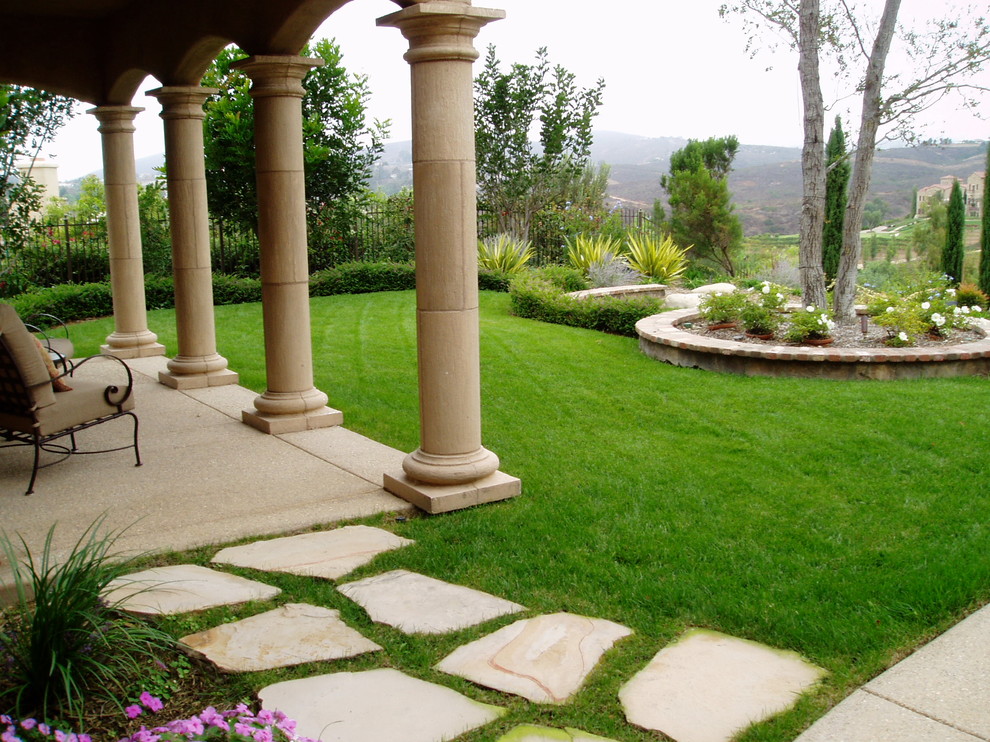 Mediterraner Garten hinter dem Haus mit Natursteinplatten in San Diego