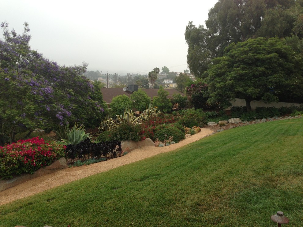 Inspiration for a mid-sized eclectic drought-tolerant and partial sun hillside gravel landscaping in San Diego.