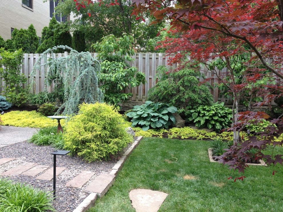 This is an example of a medium sized modern side partial sun garden in St Louis with an outdoor sport court and natural stone paving.
