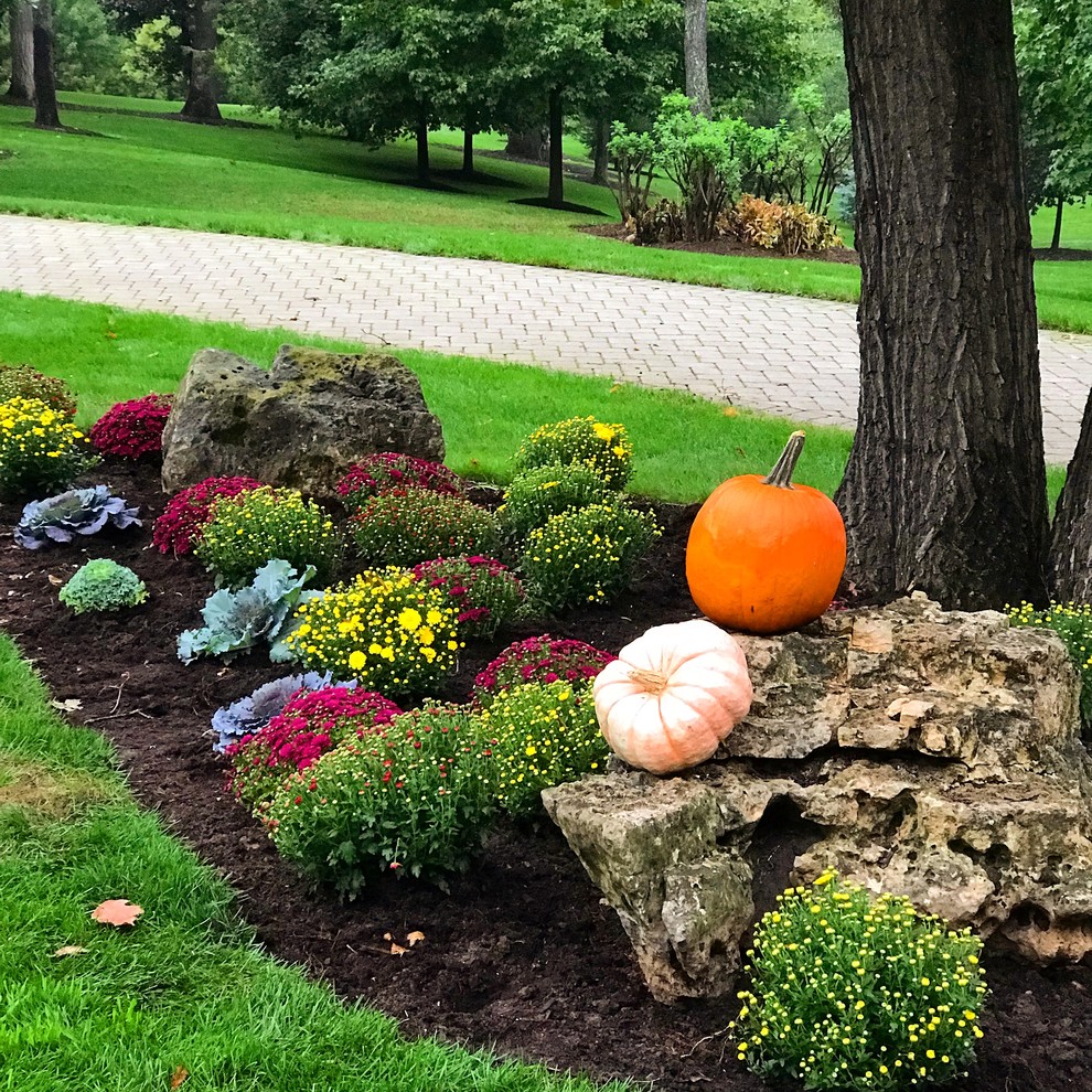 Photo of a large traditional full sun front yard brick landscaping in Chicago for fall.
