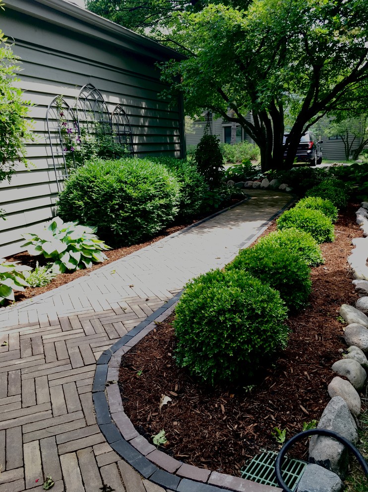 Photo of a mid-sized traditional partial sun front yard concrete paver landscaping in Chicago for summer.