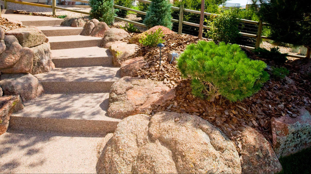 This is an example of a large classic front formal garden for winter in Denver with natural stone paving.
