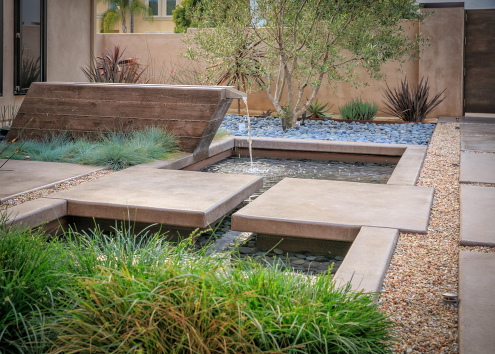 This is an example of a large contemporary front xeriscape full sun garden in San Diego with a water feature and gravel.