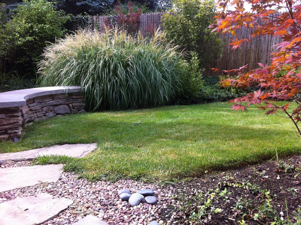 This is an example of a small traditional full sun backyard stone landscaping in Chicago.