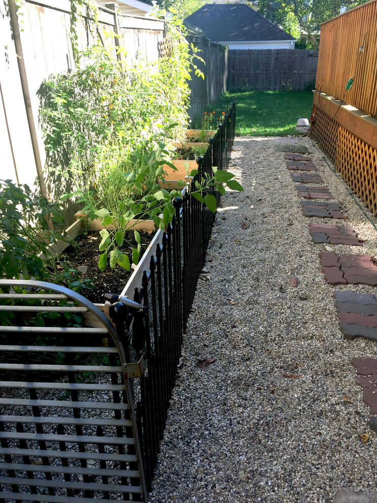 This is an example of a small classic side partial sun garden for summer in Chicago with a vegetable patch and gravel.