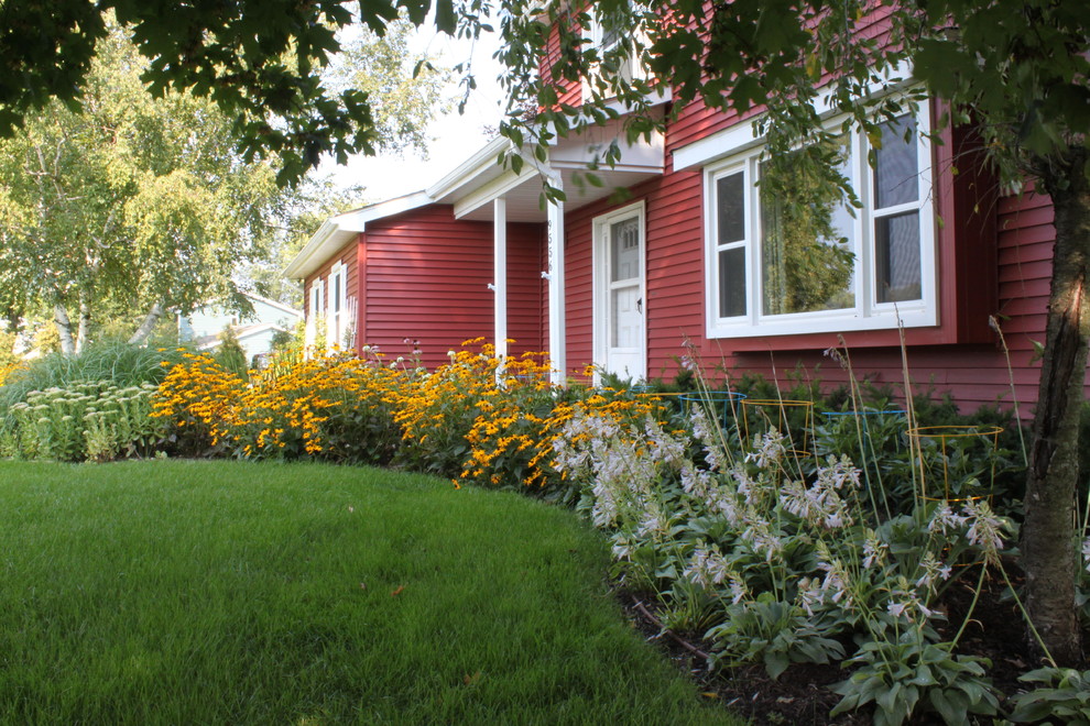 Photo of a large farmhouse partial sun front yard mulch landscaping in Detroit for summer.