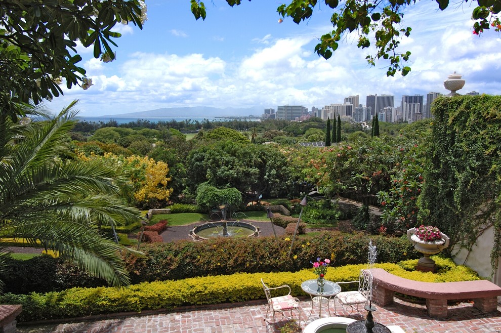 Esempio di un giardino formale tropicale esposto a mezz'ombra di medie dimensioni e dietro casa in estate con fontane e ghiaia