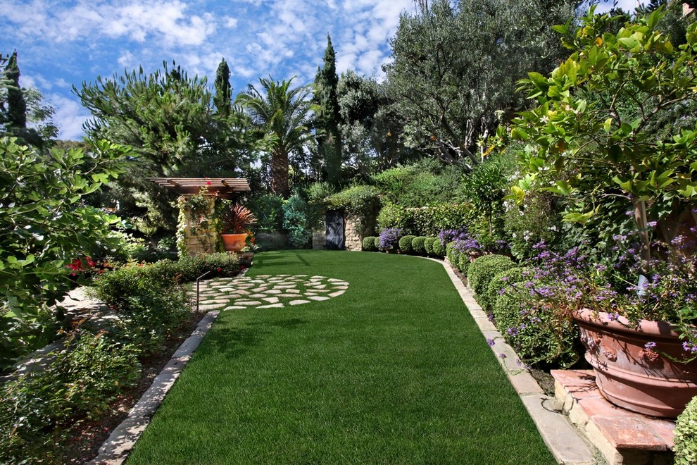 Design ideas for a huge mediterranean partial sun backyard stone formal garden in Orange County.