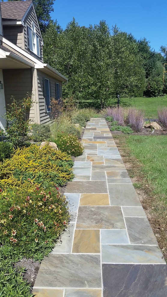 Inspiration for an expansive farmhouse front driveway full sun garden in Philadelphia with a garden path and natural stone paving.
