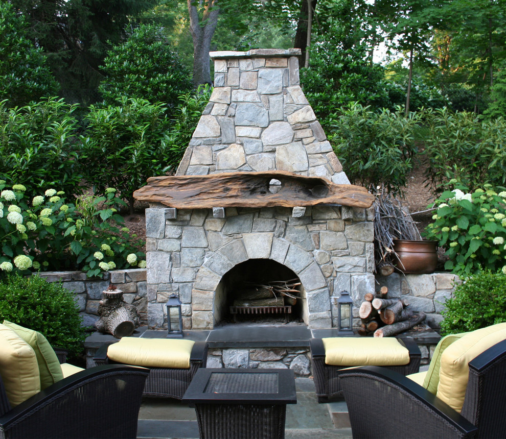 Modelo de patio ecléctico grande en patio trasero con brasero y adoquines de piedra natural