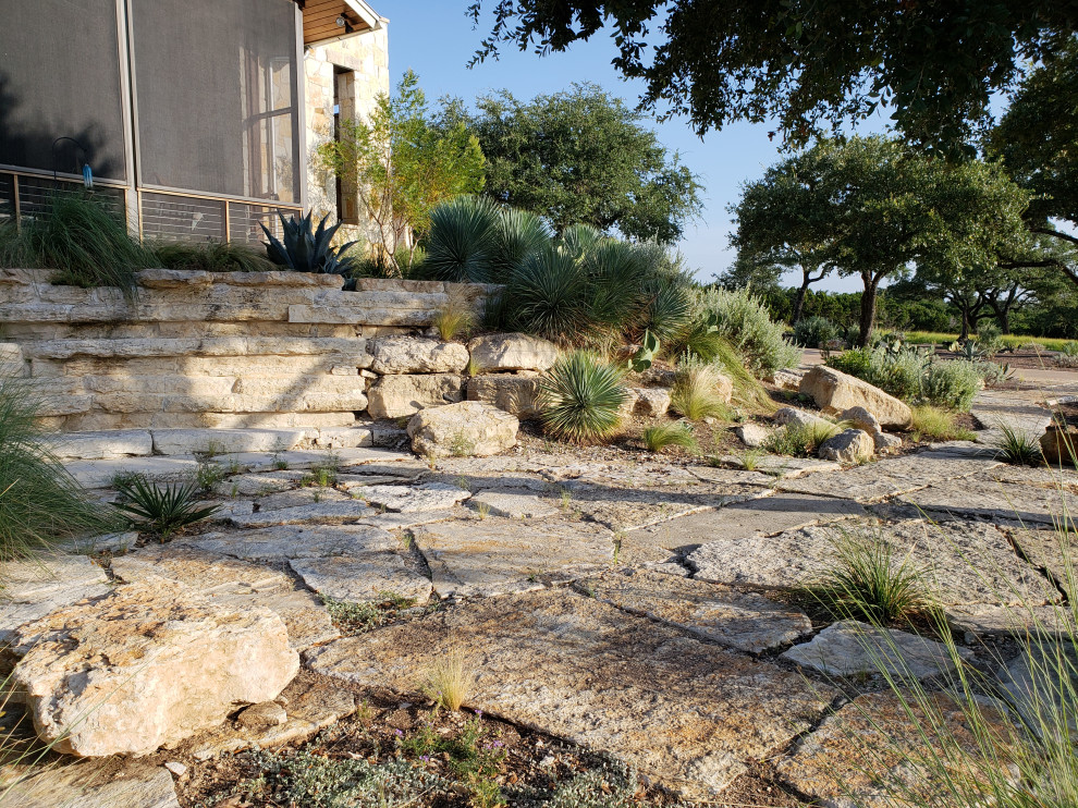 Geräumiger Mediterraner Garten mit Wüstengarten, direkter Sonneneinstrahlung und Natursteinplatten in Austin