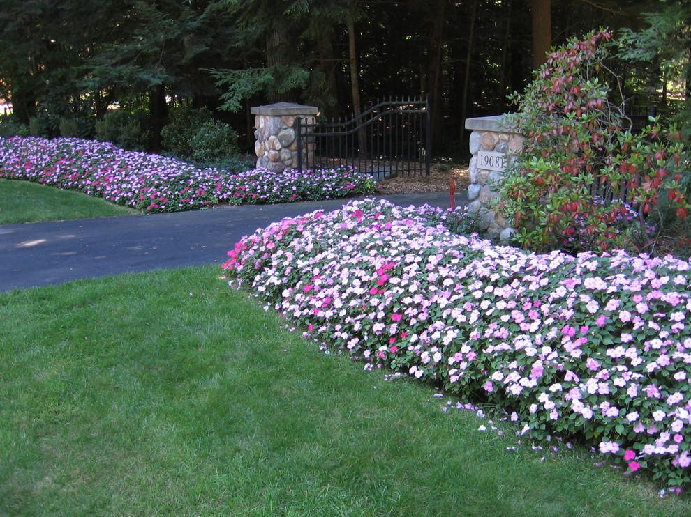 This is an example of a large classic front fully shaded garden for summer in Grand Rapids.