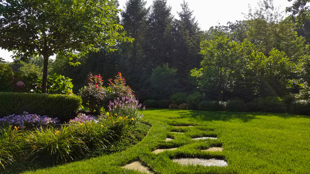 Imagen de jardín tradicional grande en patio delantero con exposición total al sol y gravilla