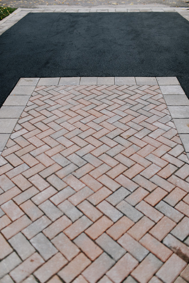 Photo of a large traditional front yard brick driveway in Toronto for fall.