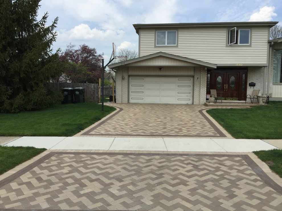 This is an example of a large traditional full sun front yard stone driveway in Chicago.