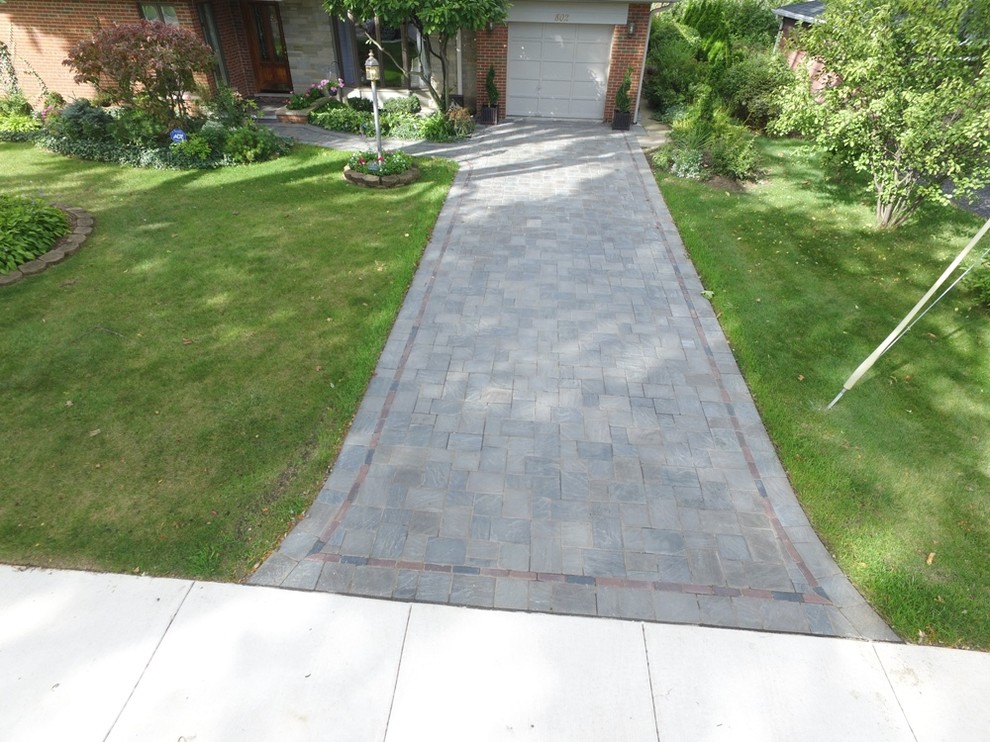 Large traditional front driveway full sun garden in Chicago with natural stone paving.