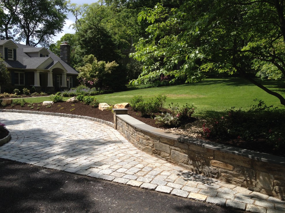 Photo of a medium sized classic front driveway partial sun garden in Philadelphia with a retaining wall and concrete paving.
