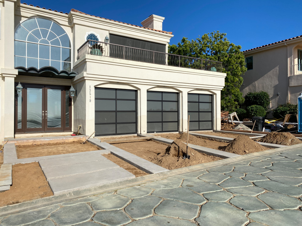 Inspiration for a large modern back formal full sun garden for summer in San Diego with concrete paving, a stone fence and a garden path.