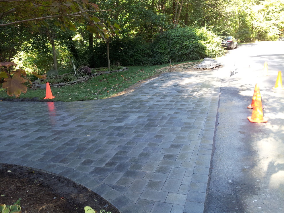 This is an example of a large traditional front driveway garden in DC Metro with concrete paving.