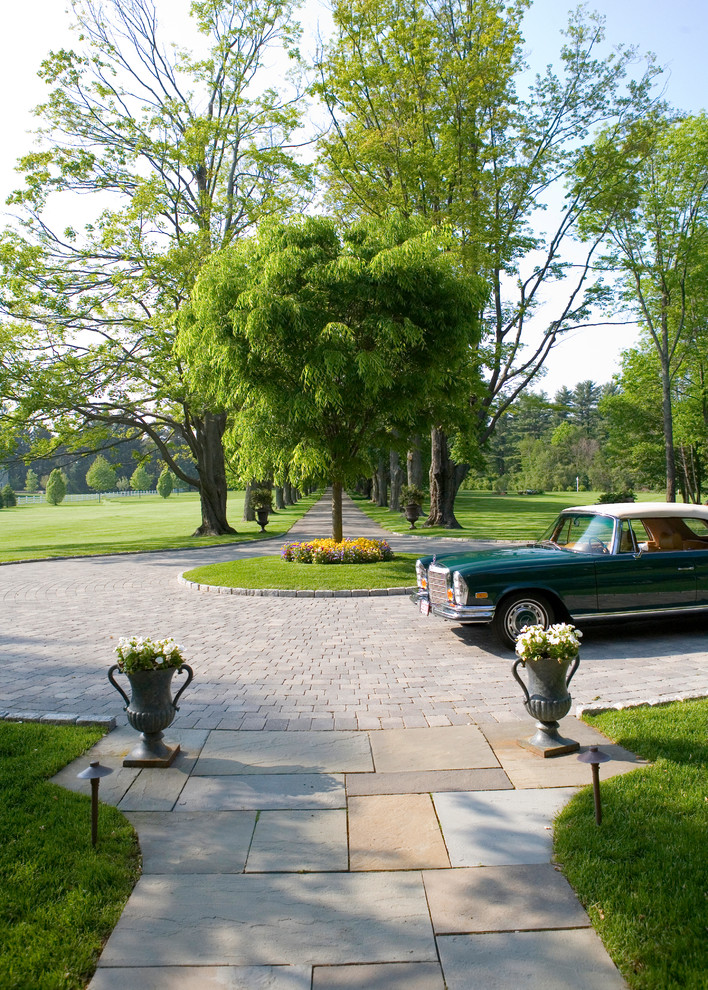 Imagen de jardín clásico grande en patio delantero con exposición parcial al sol y adoquines de piedra natural