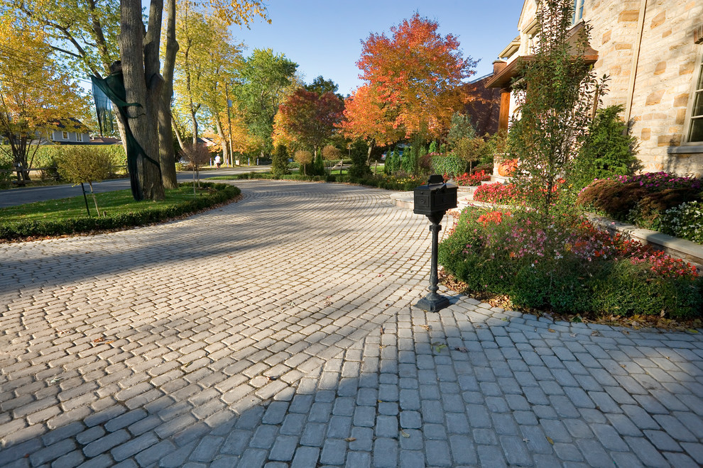 This is an example of a large traditional partial sun front yard concrete paver driveway in Philadelphia.