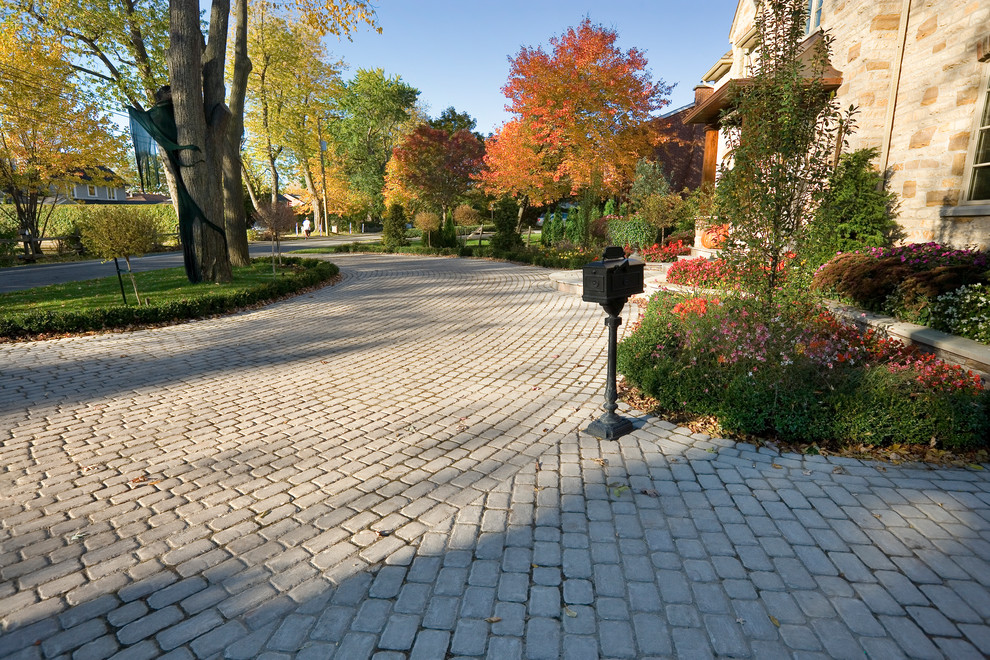 Design ideas for a large traditional front driveway partial sun garden in Philadelphia with a potted garden and concrete paving.