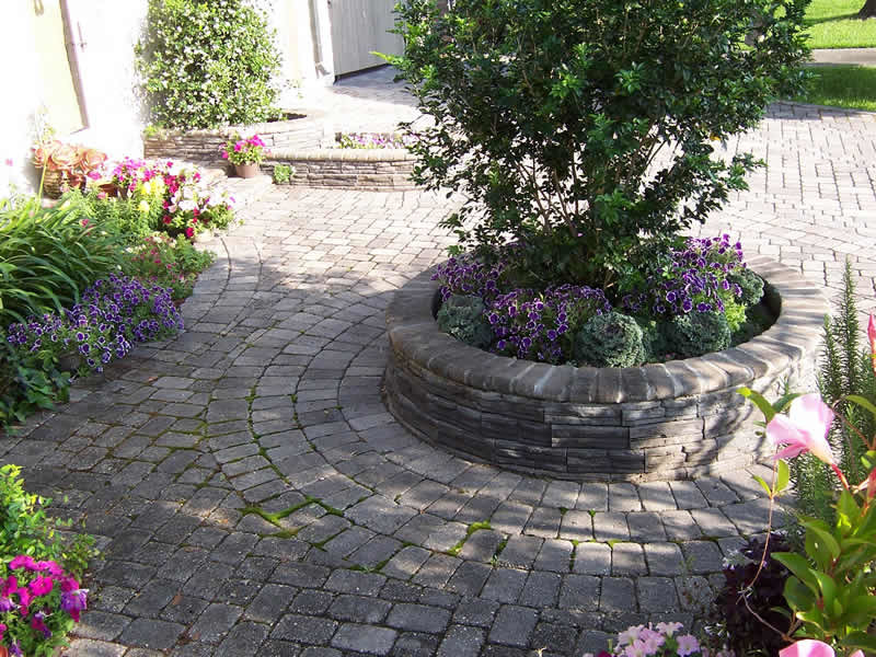 На фото: большой солнечный, весенний участок и сад на переднем дворе в классическом стиле с хорошей освещенностью и мощением тротуарной плиткой