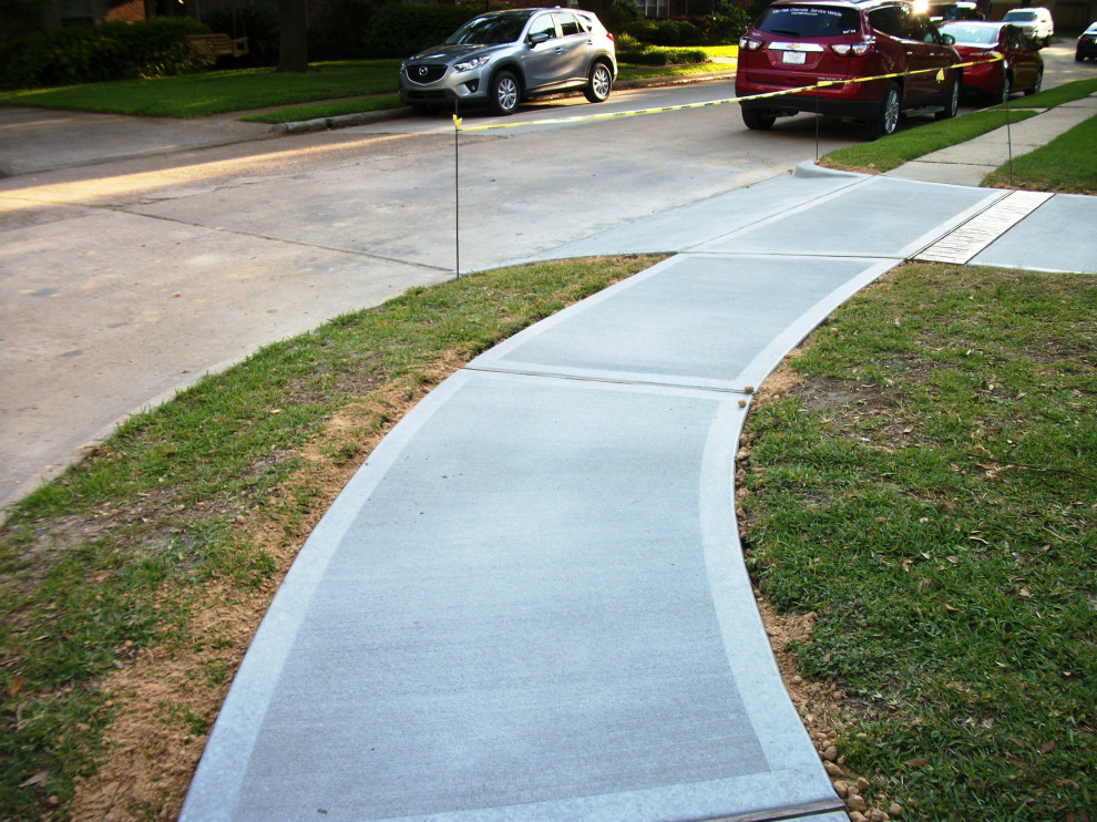 Photo of a large classic front driveway garden in Houston with concrete paving.