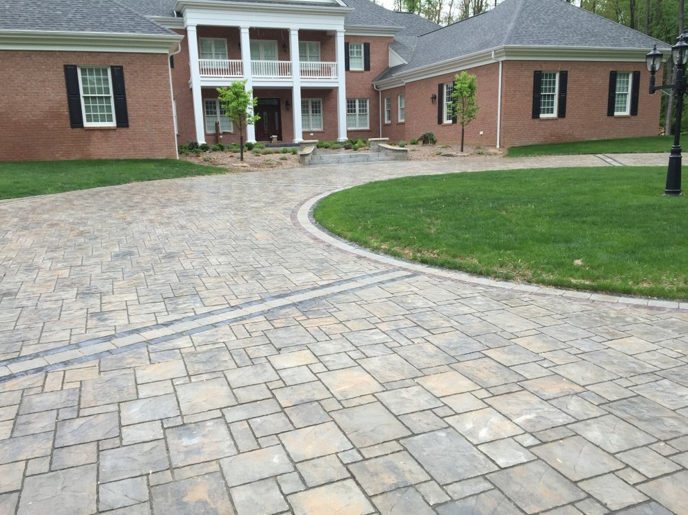 Inspiration for a large traditional front yard stone driveway in Other.