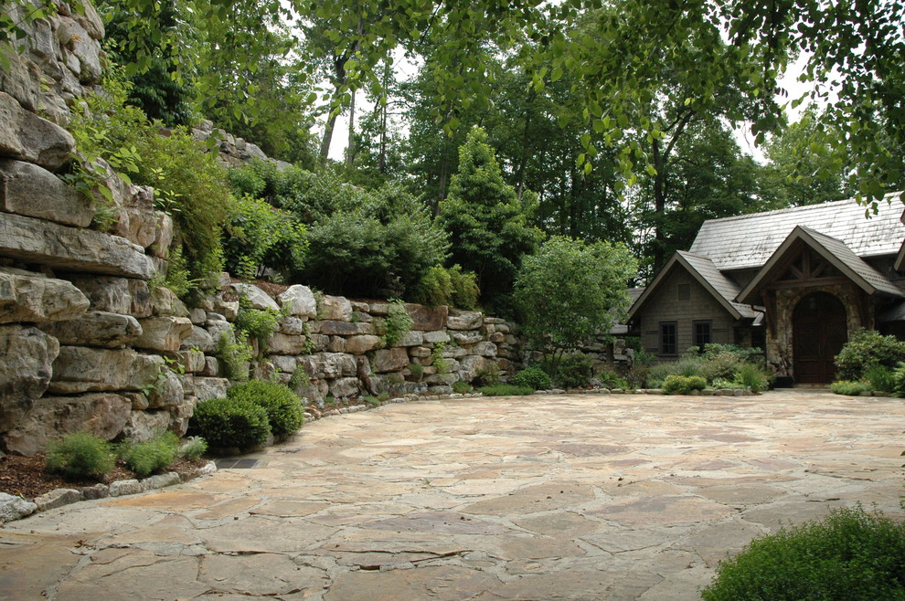 Modelo de acceso privado rústico en patio delantero con adoquines de piedra natural